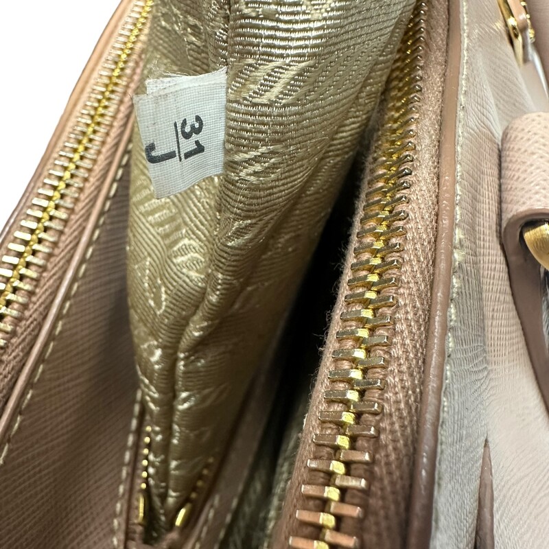 Prada Galleria Lux<br />
 Nude<br />
 Size: Medium<br />
<br />
 This tote is crafted of saffiano lux cross-grain leather in pink beige. The bag features rolled leather top handles, an optional shoulder strap with polished gold plated links, and a hanging clochette. The top opens to two full-length top zippered compartments and a Prada monogram jacquard interior with zipper and patch pockets.<br />
<br />
Dimensions:Base length: 13.5 in<br />
Height: 9.75 in<br />
Width: 5.5 in<br />
Drop: 4.5 in<br />
Drop: 16.5 in<br />
<br />
Wear shown in photos