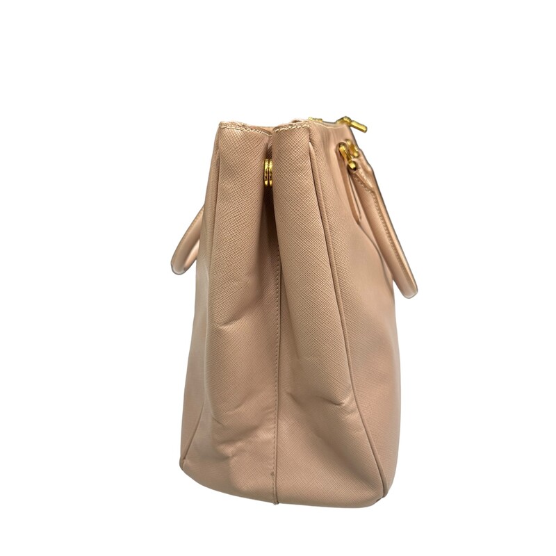 Prada Galleria Lux<br />
 Nude<br />
 Size: Medium<br />
<br />
 This tote is crafted of saffiano lux cross-grain leather in pink beige. The bag features rolled leather top handles, an optional shoulder strap with polished gold plated links, and a hanging clochette. The top opens to two full-length top zippered compartments and a Prada monogram jacquard interior with zipper and patch pockets.<br />
<br />
Dimensions:Base length: 13.5 in<br />
Height: 9.75 in<br />
Width: 5.5 in<br />
Drop: 4.5 in<br />
Drop: 16.5 in<br />
<br />
Wear shown in photos