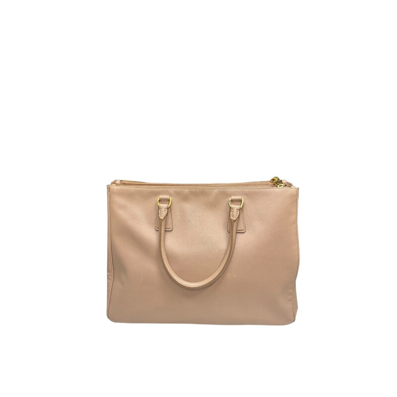 Prada Galleria Lux
 Nude
 Size: Medium

 This tote is crafted of saffiano lux cross-grain leather in pink beige. The bag features rolled leather top handles, an optional shoulder strap with polished gold plated links, and a hanging clochette. The top opens to two full-length top zippered compartments and a Prada monogram jacquard interior with zipper and patch pockets.

Dimensions:Base length: 13.5 in
Height: 9.75 in
Width: 5.5 in
Drop: 4.5 in
Drop: 16.5 in

Wear shown in photos