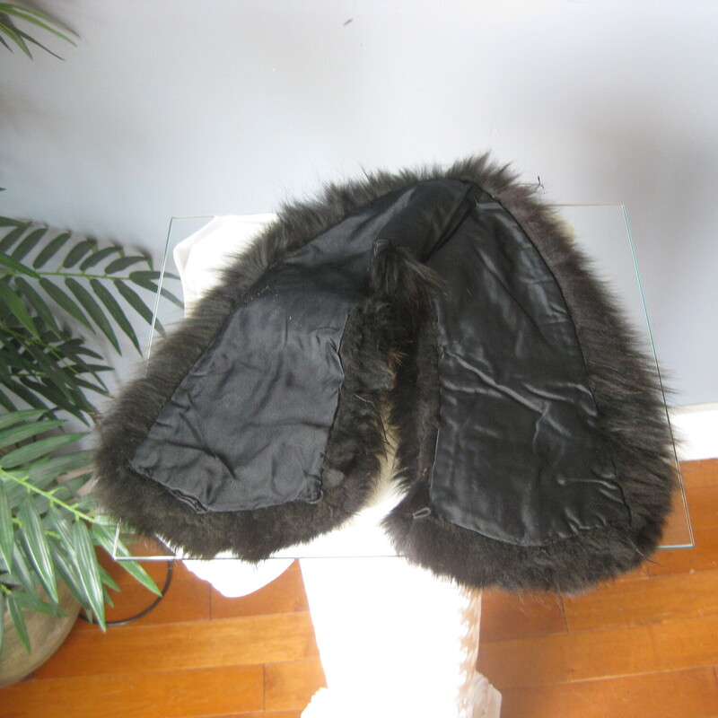 This is a simple black fur collar that probably came from a 1950s coat. It's really nicely made and in great condition and ready to be attached to a new coat! You could also pin it around the base of your neck using the existing hook and eye closure. Add it to a simple crew neck top or sweater for a touch a warm and luxury. Or wear on your bare skin above a strapless bodice, it will feel fabulous and lend an air of uniqueness to your high fashion looks.<br />
<br />
The fur is long and luxurious. very soft. It's not mink - no guard hairs, it'snot rabbit either, too long.... dyed fox - I think it might be too soft even for fox.<br />
<br />
It measure aproximately 22 along the top edges where the hook and eye closure is end to end of the satin lining on the underside. So it will sit high on the neck pretty similar to how you see it on the dress form.<br />
<br />
It's made of a very dark fur, reads black but has brown dimension<br />
excellent condition, no shedding, fresh and soft<br />
Thank you for looking!<br />
#71616