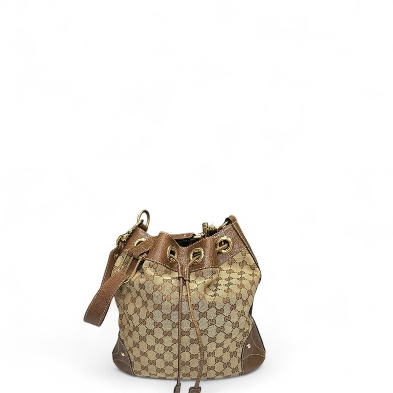 GUCCI Monogram Drawstring Shoulder Bag in Brown. This stylish tote is crafted of signature brown Gucci GG canvas. The bag features brown leather accents including a shoulder strap with bold hosebit inspired brass links, structuring at the base, sides and top crest, and a draw-string closure.
Style Code:141608 20527
Some discoloration on back