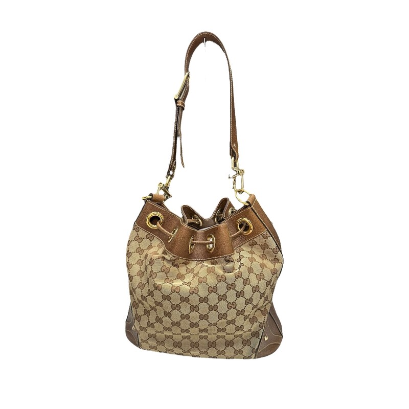 GUCCI Monogram Drawstring Shoulder Bag in Brown. This stylish tote is crafted of signature brown Gucci GG canvas. The bag features brown leather accents including a shoulder strap with bold hosebit inspired brass links, structuring at the base, sides and top crest, and a draw-string closure.<br />
Style Code:141608 20527<br />
Some discoloration on back