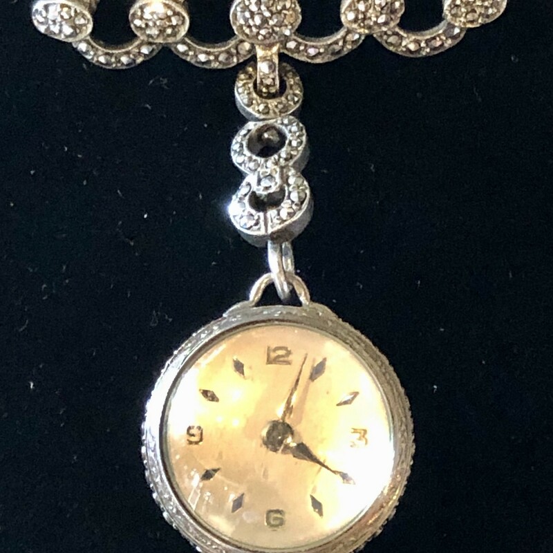 This amazing  watch has a beautiful brooch with secure pin closure and suspends an articulated swinging marcasite encrusted section to hold the ball watch. The watch itself is encircled with bands of shining marcasite. The cream dial has silver markers for the minutes and is marked for Bucherer, 17 Jewel, 800 silver.<br />
<br />
The condition of this piece is excellent  and the watch is currently working. This is a timeless and elegant timepiece.