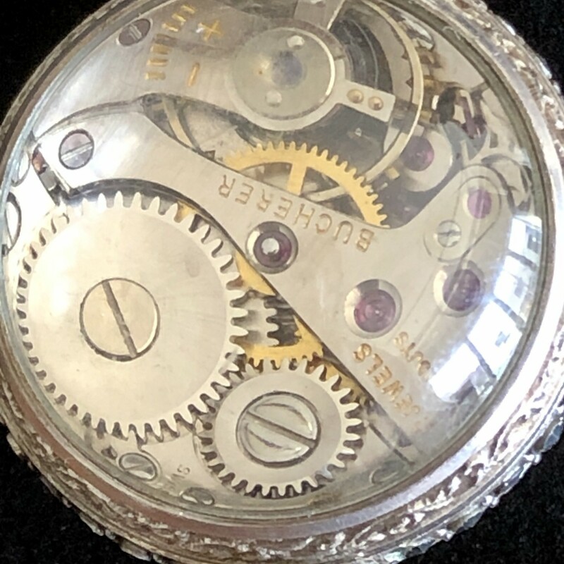 This amazing  watch has a beautiful brooch with secure pin closure and suspends an articulated swinging marcasite encrusted section to hold the ball watch. The watch itself is encircled with bands of shining marcasite. The cream dial has silver markers for the minutes and is marked for Bucherer, 17 Jewel, 800 silver.<br />
<br />
The condition of this piece is excellent  and the watch is currently working. This is a timeless and elegant timepiece.