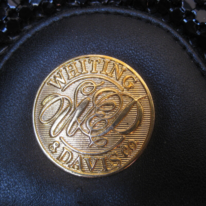 One of Whiting & Davis' later designs.  I think this is from the 1980s<br />
structured bag with removeable leather strap<br />
Black<br />
Two main compartments and 1 zippered pocket on the inside and one slip pocket on the outside<br />
Cool embossed gold medallion on the flap wich close with a magnetic snap.<br />
fully lined with company logo fabric<br />
one zippered pocket and one slip pocket.<br />
The strap is thin, made of leather and can be removed and/or adjusted in length.<br />
Great vintage condtiion.<br />
Measurements:<br />
11.5 x 8 x 1.75<br />
<br />
thanks for looking!<br />
#71264