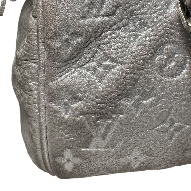 LOUIS VUITTON Monogram Shimmer Comete in Silver. This chic tote is crafted of Louis Vuitton metallic embossed light pink shimmery leather. The bag features leather straps with polished silver links and a decorative frontal silver plate from which is suspended a silver tipped leather tassel. The top zipper opens to a gray fabric interior with a patch pocket.

Dimensions:
Base length: 12 in
Height: 6.5 in
Width: 8 in
Drop: 9 in

Exterior: Some Discoloration/ fading,  and edge wear

Date Code: AR3068