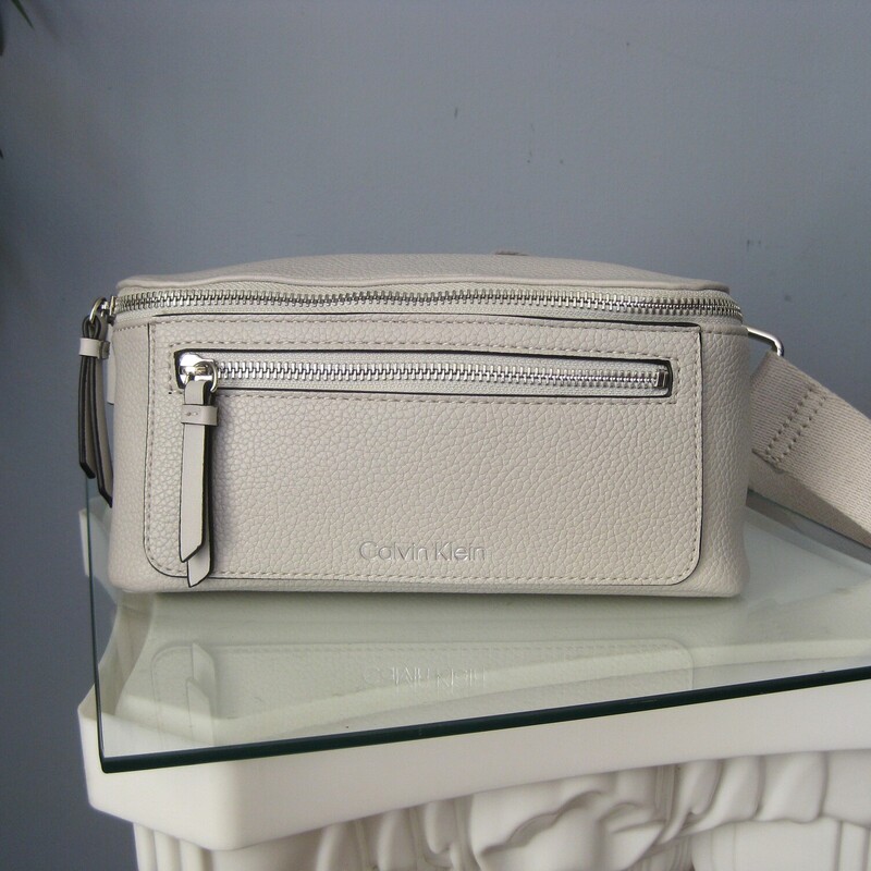 Calvin Klein Waist, Gray, Size: N<br />
Sleek, chic and secure.<br />
Calvin Klein bag that can be worn as a belt bag or (better) as a sling. The strap is quite long, too long for me to wear it at my waist, my waist is about 30<br />
It has a wide web adjustable strap with a heavy duty clasp.<br />
One zipper pocket on the outside and one on the inside.<br />
9 wide<br />
4.25 high<br />
3 deep<br />
<br />
perfect, like new condition.<br />
thanks for looking!<br />
#79086