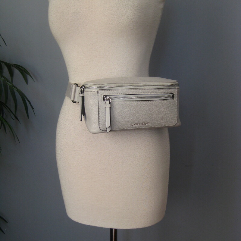 Calvin Klein Waist, Gray, Size: N<br />
Sleek, chic and secure.<br />
Calvin Klein bag that can be worn as a belt bag or (better) as a sling. The strap is quite long, too long for me to wear it at my waist, my waist is about 30<br />
It has a wide web adjustable strap with a heavy duty clasp.<br />
One zipper pocket on the outside and one on the inside.<br />
9 wide<br />
4.25 high<br />
3 deep<br />
<br />
perfect, like new condition.<br />
thanks for looking!<br />
#79086