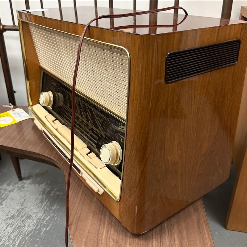 German Vintage Radio, Caramel Brown/Wood. Plugs in and illuminates - but some trouble functioning. Come on by to give it a test for yourself.<br />
Size: 26x15x12