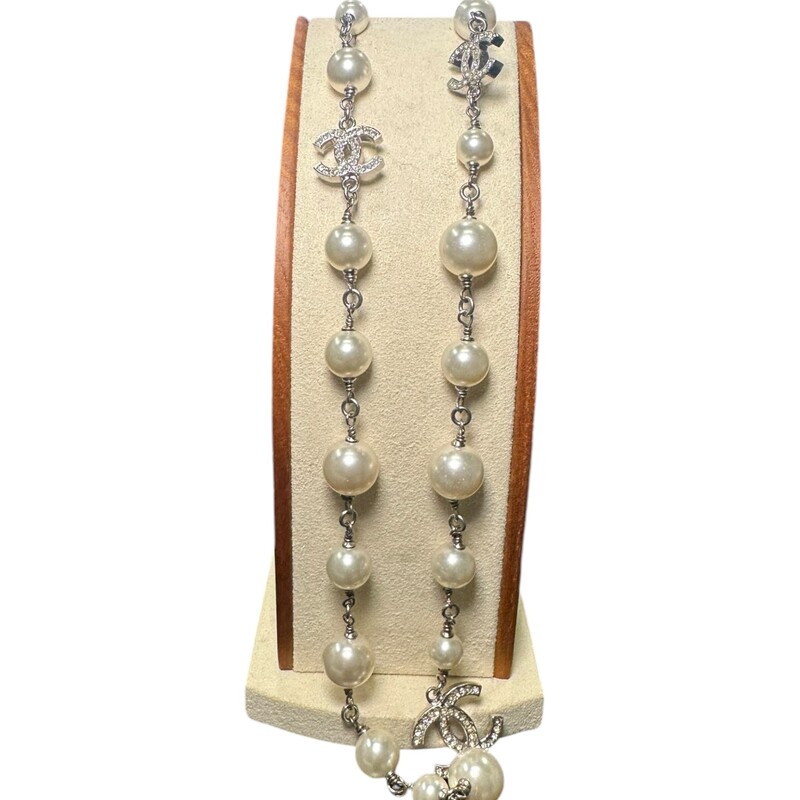 CHANEL Graduated Pearl Crystal CC Long Necklace in Silver. This piece is a long strand of various-sized faux pearls separated by silver-toned links and silver set Chanel CC logos encrusted with crystals.<br />
*Some yellowing of stones<br />
Code: O9 P<br />
<br />
Length: 41 in<br />
Width: 0.75 in<br />
<br />
Comes with dust bag and box