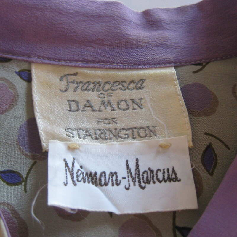 Francesca Damon Silk, Gray, Size: 10<br />
Here is a pretty silk dress is soft grays and lavender with a subtle floral print.<br />
It's from the 1980s.<br />
by Francesca Damon for Starington and it was purchased at Neiman Marcus.<br />
Made in Hong Kong<br />
The dress has hidden buttons all the way down the front.<br />
It has a high collar with attached sash ties.<br />
It comes with a matching sash, wider than the neck ties but not long enough to serve as a belt.<br />
Unlined<br />
Pockets<br />
Long sleeves with button cuffs<br />
small shoulder pads.<br />
it's marked size 10 but use these measurements to be sure it will fit. It seems like it will fit larger than a modern size 10.<br />
Flat measurements:<br />
Shoulder to shoulder: 14.5<br />
armpit to armpit: 23.5<br />
Waist: 24<br />
Hip: up to 25<br />
Length: 44<br />
Underarm sleeve seam: 19 (sleeve buttons at the end)<br />
<br />
perfect condition!<br />
<br />
Thanks for looking!<br />
#72244