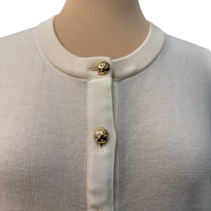 Kate Spade Wool Cardigan<br />
Bejeweled Buttons<br />
Ribbon Accent<br />
3/4 Sleeve<br />
100% Wool<br />
Color: Cream<br />
Size: Medium