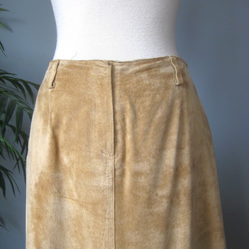 Here is a great separate for your vintage wardrobe.  It's a warm beige midi skirt in suede by Margaret Godfrey.<br />
simple with a front fly (zipper and slide hook and eye) and button loops at the top.<br />
Fully lined<br />
Heavy!<br />
A super versatile piece in super shape.<br />
Here are the flat measurements, please double where appropriate:<br />
Marked size 6 but best for a size 4 imo<br />
Waist: 15.25<br />
Hips: 20.5<br />
Length: 37.25<br />
<br />
Thank you for looking.<br />
#79838