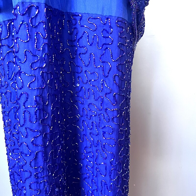 Floor length Silk Beaded Gown in royal blue. The dress was made in India. The base is silk.<br />
It has a two piece look - both 'pieces' are fully beaded.<br />
The tunic look top layer has a pretty scalloped hem.<br />
Short Sleeves and moderate shoulders to support the substantial weight of the dress.<br />
Kick vent in the back measures 18<br />
Center back zipper<br />
Brand: Brilliante<br />
<br />
marked size 1X<br />
Flat measurements:<br />
shoulder to shoulder: 18<br />
armpit to armpit: 23.5<br />
waist: 23.5<br />
hip: 24'<br />
length: 54<br />
Excellent vintage condition!<br />
Thanks for looking<br />
#76107