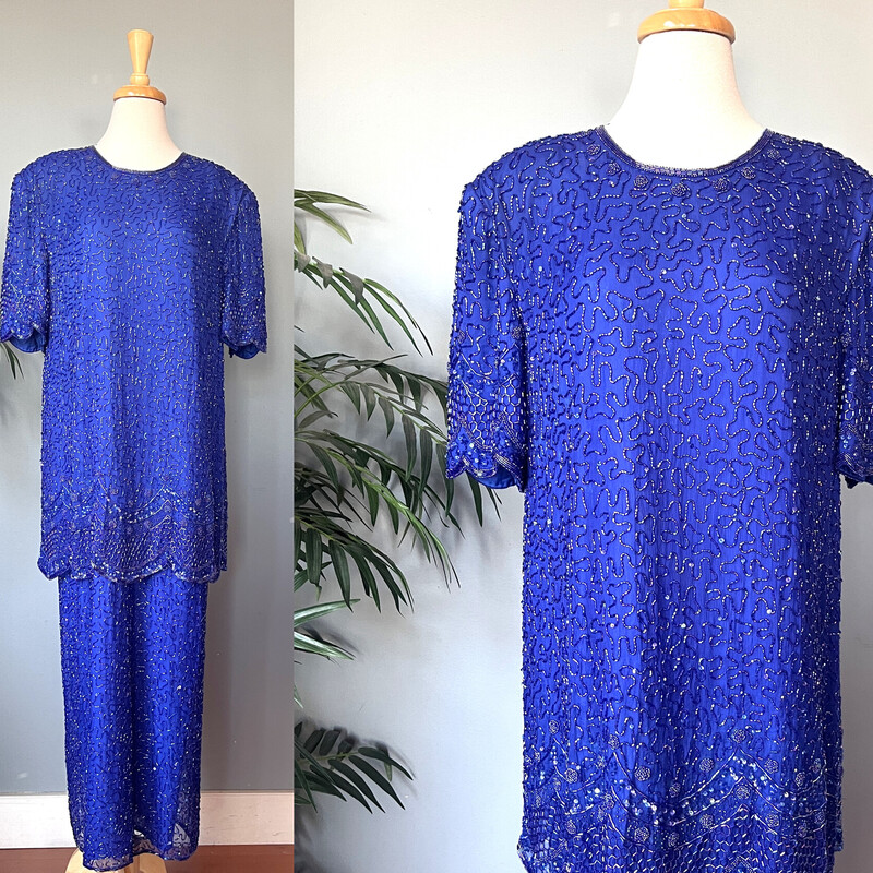 Floor length Silk Beaded Gown in royal blue. The dress was made in India. The base is silk.
It has a two piece look - both 'pieces' are fully beaded.
The tunic look top layer has a pretty scalloped hem.
Short Sleeves and moderate shoulders to support the substantial weight of the dress.
Kick vent in the back measures 18
Center back zipper
Brand: Brilliante

marked size 1X
Flat measurements:
shoulder to shoulder: 18
armpit to armpit: 23.5
waist: 23.5
hip: 24'
length: 54
Excellent vintage condition!
Thanks for looking
#76107