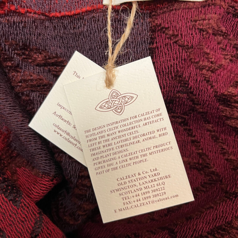 New Calzeat Celtic Ruana<br />
New With Tags<br />
Woven Celctic Design<br />
Wool Blend with Fringe Detail<br />
Designed and Woven in Scotland<br />
Colors:  Red and Plum<br />
Retails for $161.00