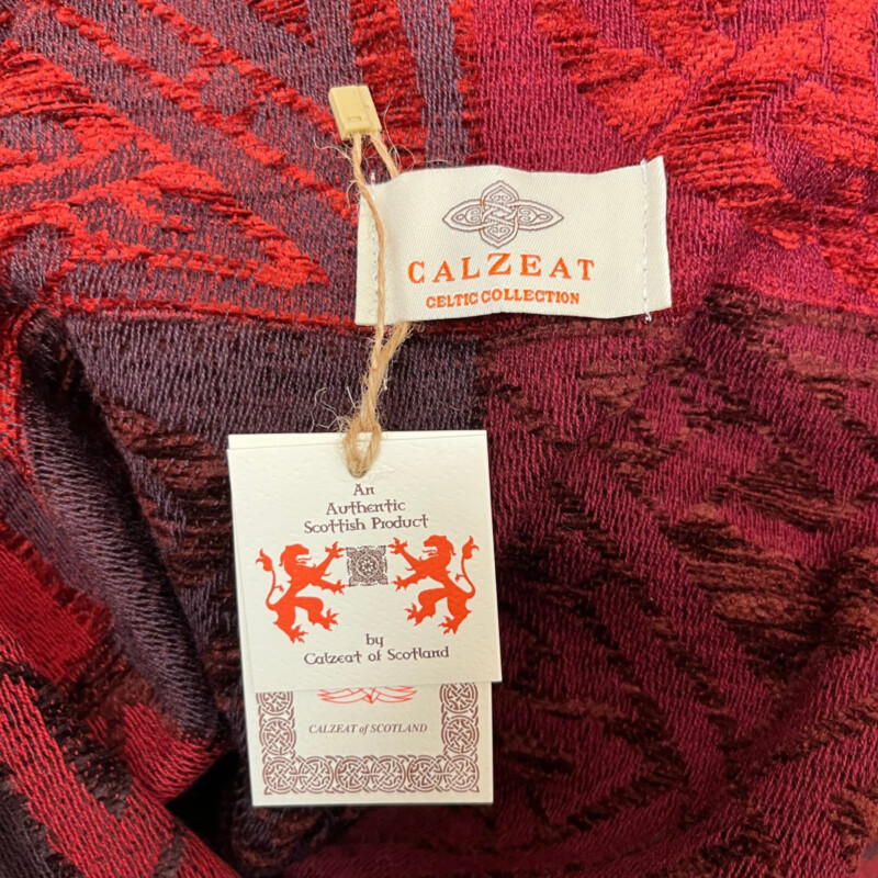 New Calzeat Celtic Ruana<br />
New With Tags<br />
Woven Celctic Design<br />
Wool Blend with Fringe Detail<br />
Designed and Woven in Scotland<br />
Colors:  Red and Plum<br />
Retails for $161.00