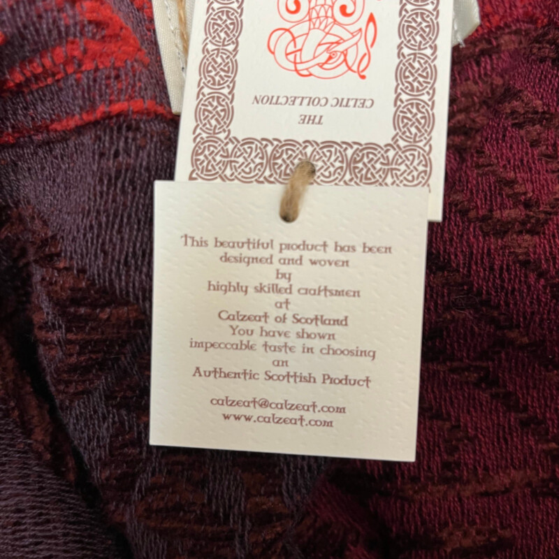 New Calzeat Celtic Ruana<br />
New With Tags<br />
Woven Celctic Design<br />
Wool Blend with Fringe Detail<br />
Designed and Woven in Scotland<br />
Colors:  Red and Plum<br />
Retails for $161.00