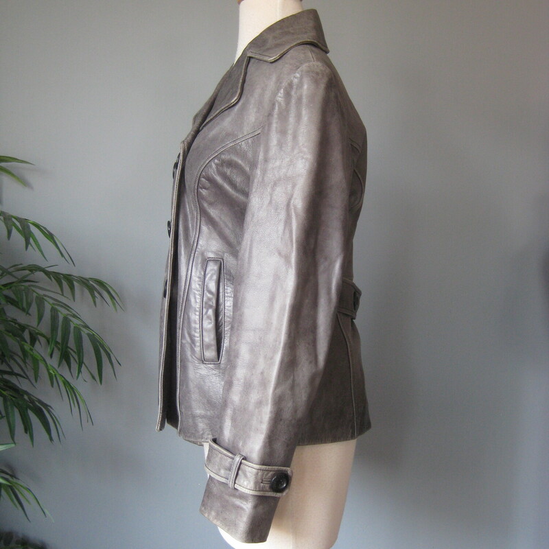 Guess Leather Moto, Gray, Size: Medium<br />
This simple hip length double breasted gray leather jacket has a bit of an edge but wearable to work and any other occasion.  Trench details, peacoat adjacet it's fully line with side pockets and straps at the end of the cuffs.<br />
Button closures<br />
It has pockets and a high and wide notched lapel<br />
<br />
Excellent pre-owned condition!<br />
It's marked size M, but I am calling it a small.  The measurements, as you will see are too small for a modern size M, I am a size medium and I tried it on and it was too snug for me all over.<br />
<br />
Here are the flat measurements:<br />
Shoulder to shoulder: 15.75<br />
Armpit to armpit: 19.5<br />
Width at hem: 18<br />
Length: 25<br />
underarm sleeve seam: 17<br />
<br />
Thanks for looking!<br />
#80698