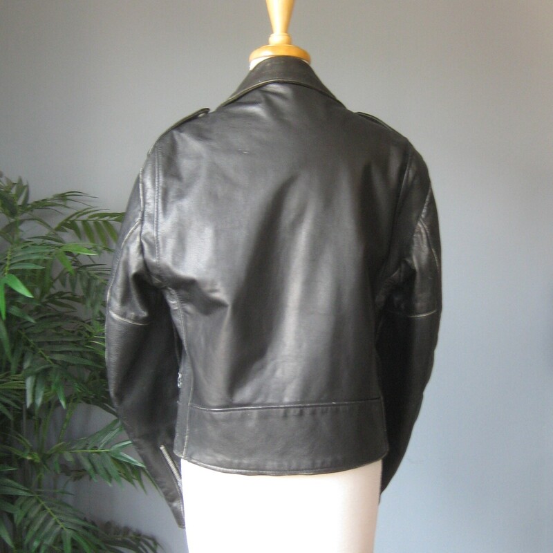 Vtg Dur O Jac Leather Mot, Black, Size: Medium<br />
Here's a classic black leather motorcycle jacket from Dur O Jac with silver hardware.  It has a buckling belt and silver zippers on the front, sleeves and pockets.<br />
I believe it dates from the 1980s<br />
This jacket is in perfect wearable condition, has been worn - a lot - well broken in.<br />
It has edgewear and scuffs in quite a few places but no deep scratches or missing or broken hardware.<br />
The jacket has quilted lining 3 zippered pockets on the front.<br />
Also 'ticket' pocket with a snap closure, this pocket is deeper than you might expect.  I don't think a modern phone will fit though.<br />
Shoulder epaullettes.<br />
Marked size M<br />
I am a medium, about size 10 this jacket is too tight on me.  So if you are a modern size 6 or 8 it should work for you.<br />
Flat measurements, please double where appopriate:<br />
Shoulder to shoulder : 18<br />
Armpit to armpit: 21<br />
Width at hem: 18<br />
Underarm sleeve seam: 18<br />
Length: 25<br />
<br />
Thank you for looking<br />
#80783