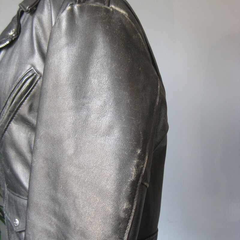 Vtg Dur O Jac Leather Mot, Black, Size: Medium<br />
Here's a classic black leather motorcycle jacket from Dur O Jac with silver hardware.  It has a buckling belt and silver zippers on the front, sleeves and pockets.<br />
I believe it dates from the 1980s<br />
This jacket is in perfect wearable condition, has been worn - a lot - well broken in.<br />
It has edgewear and scuffs in quite a few places but no deep scratches or missing or broken hardware.<br />
The jacket has quilted lining 3 zippered pockets on the front.<br />
Also 'ticket' pocket with a snap closure, this pocket is deeper than you might expect.  I don't think a modern phone will fit though.<br />
Shoulder epaullettes.<br />
Marked size M<br />
I am a medium, about size 10 this jacket is too tight on me.  So if you are a modern size 6 or 8 it should work for you.<br />
Flat measurements, please double where appopriate:<br />
Shoulder to shoulder : 18<br />
Armpit to armpit: 21<br />
Width at hem: 18<br />
Underarm sleeve seam: 18<br />
Length: 25<br />
<br />
Thank you for looking<br />
#80783