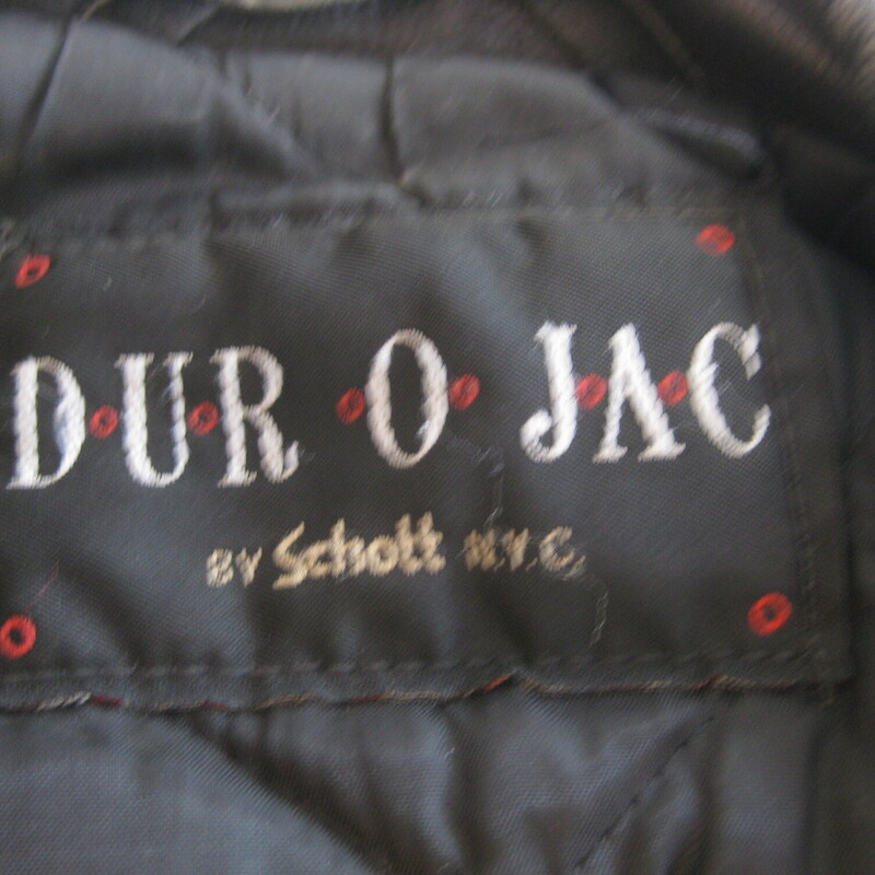 Vtg Dur O Jac Leather Mot, Black, Size: Medium<br />
Here's a classic black leather motorcycle jacket from Dur O Jac with silver hardware.  It has a buckling belt and silver zippers on the front, sleeves and pockets.<br />
I believe it dates from the 1980s<br />
This jacket is in perfect wearable condition, has been worn - a lot - well broken in.<br />
It has edgewear and scuffs in quite a few places but no deep scratches or missing or broken hardware.<br />
The jacket has quilted lining 3 zippered pockets on the front.<br />
Also 'ticket' pocket with a snap closure, this pocket is deeper than you might expect.  I don't think a modern phone will fit though.<br />
Shoulder epaullettes.<br />
Marked size M<br />
I am a medium, about size 10 this jacket is too tight on me.  So if you are a modern size 6 or 8 it should work for you.<br />
Flat measurements, please double where appopriate:<br />
Shoulder to shoulder : 18<br />
Armpit to armpit: 21<br />
Width at hem: 18<br />
Underarm sleeve seam: 18<br />
Length: 25<br />
<br />
Thank you for looking<br />
#80783