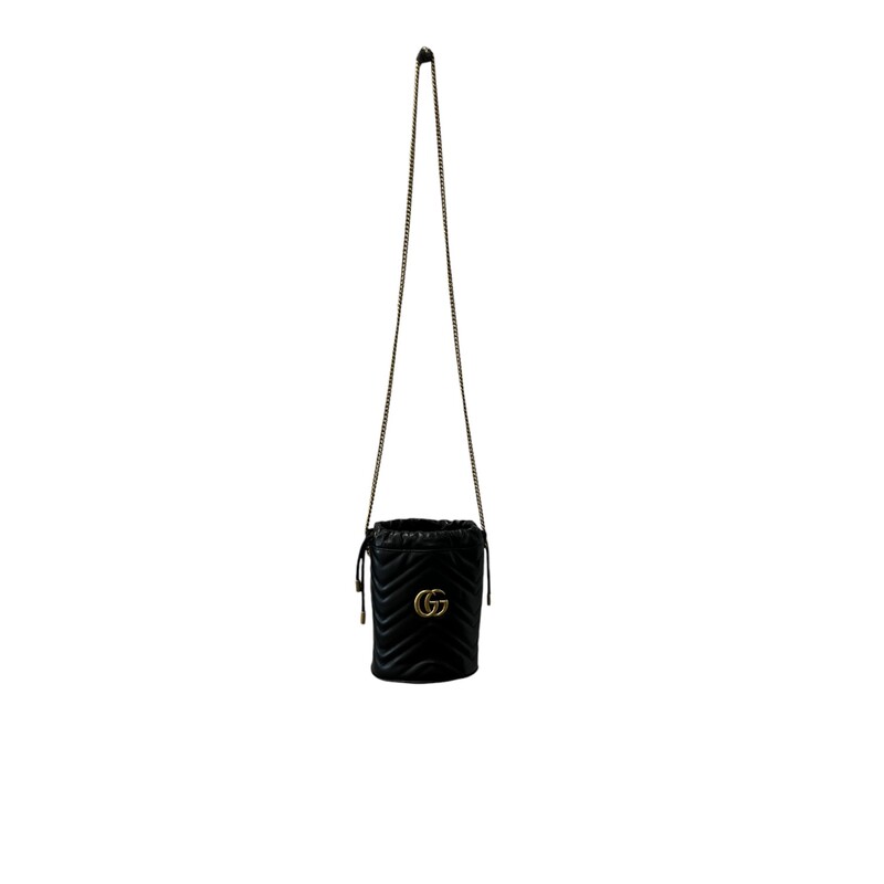 GUCCI Calfskin Matelasse Mini GG Marmont 2.0 Bucket Bag in Black. This soft-structured bucket bag is crafted of soft calfskin leather in black with a beautifully stitched chevron pattern. It features an aged gold chain shoulder strap, a top cinch cord and an aged gold interlocking GG logo. On the back of this beautifully crafted bag, there is a heart stitched design. This bag opens to a beige microfiber interior with card slots and a removable key ring.<br />
Dimensions:<br />
Base length: 5 in<br />
Height: 7 in<br />
Width: 4.25 in<br />
Drop: 22.5 in<br />
Condition: Some minor marks on the inside  otherwise in great shape