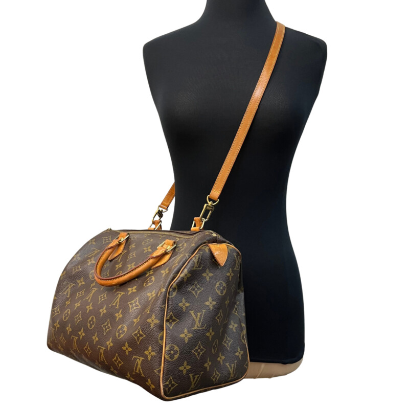 Louis Vuitton Speedy 30 Handbag<br />
Quality Made Leather with Monogram Print<br />
Top Handle Bag with Strap<br />
From the 1991 Collection<br />
Brown Coated Canvas<br />
Brass Hardware<br />
Rolled Handles<br />
Leather Trim Embellishment<br />
Canvas Lining & Single Interior Pocket<br />
Zip Closure at Top