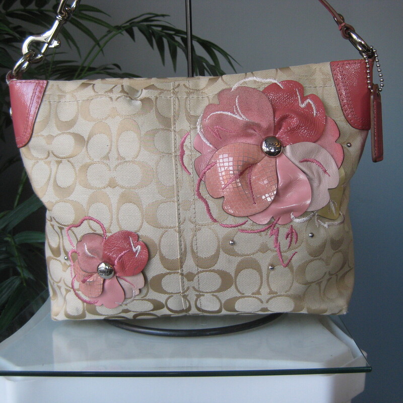 Coach Logo Lthr Flowers, Tan/pink, Size: None<br />
Pretty and girly Coach Carly bag.<br />
<br />
Light brown coach logo jacquared with studs and leather and suede flowers attached to the outside.<br />
Pink patent leather trim and Coach logo hangtag<br />
Silver hardware, top zipper,<br />
baby pink satin interior with two slip pockets and one zippered pocket.<br />
The handle is removeable.<br />
11 x 8.5 x 3.5 at the bottom, a bit less deep at the top<br />
Handle drop: 7.5<br />
<br />
excellent condition.  The pink flowers have some darkness at the highest relief points, please see all the photos.<br />
thanks for looking!<br />
#80375