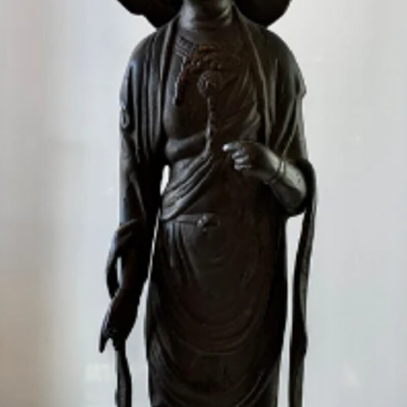 Vintage Kannon Bosatsu Goddess of Mercy
Black Cast Iron from 1920s
Size: 6x6x24H
A rich surface texture and encrustation of iron rust in black. The style and proportions of the statue point to an earlier Chinese influence. The simple form of the compassion Bodhisattva backed by a flaming mandorla is appealing in its archaic presence.
Kannon is holding a removable lotus.
Circa 19-20th century standing atop a double lotus base wearing long flowing robes and tall pointed headdress with elaborate sectional mandorla exhibiting raised detailing aureola aura placed above her shoulders which has become loosened over time.
Retail $2K