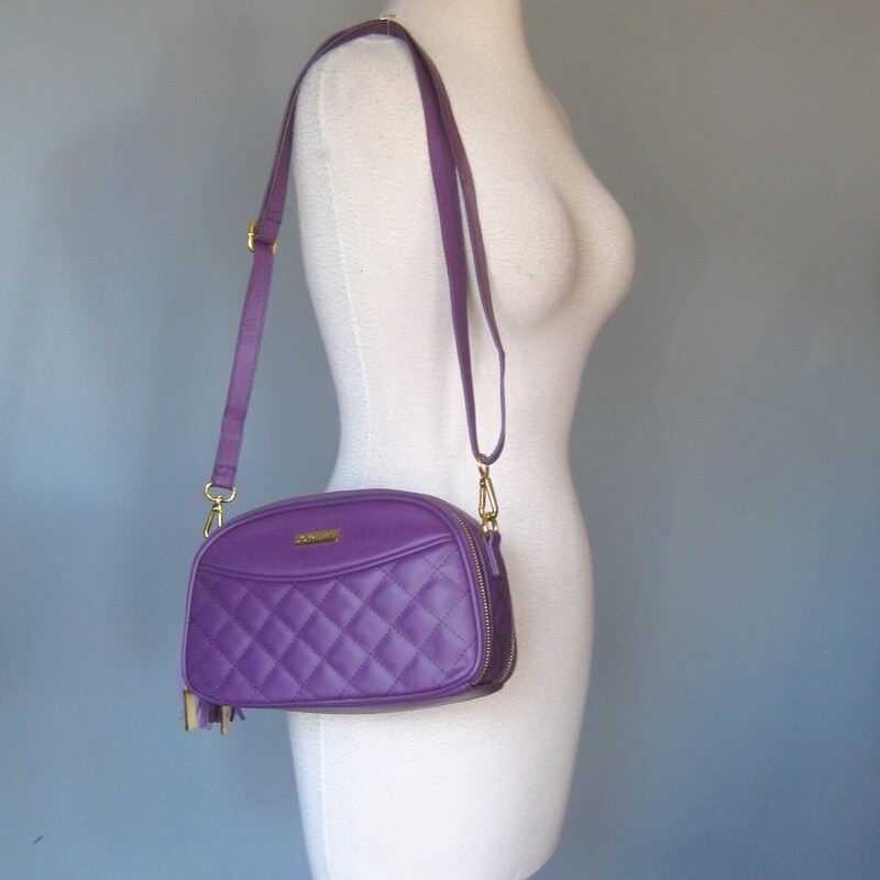 Double sided crossbody bag from Joy & Iman Joy Mangano<br />
Irresistable shade of Purple<br />
Quilted Crossbody Bag<br />
New without tags<br />
<br />
10-inches wide<br />
6-inches high<br />
3-inches deep<br />
Oval Shape<br />
Outer magnetic slip pocket<br />
2 zip compartments<br />
Card slots<br />
inner dividers<br />
Tassel bag charm (non-removable)<br />
Adjustable strap, 27  max, 14 minimum<br />
<br />
Like new condition!<br />
Thanks for looking!<br />
#81205