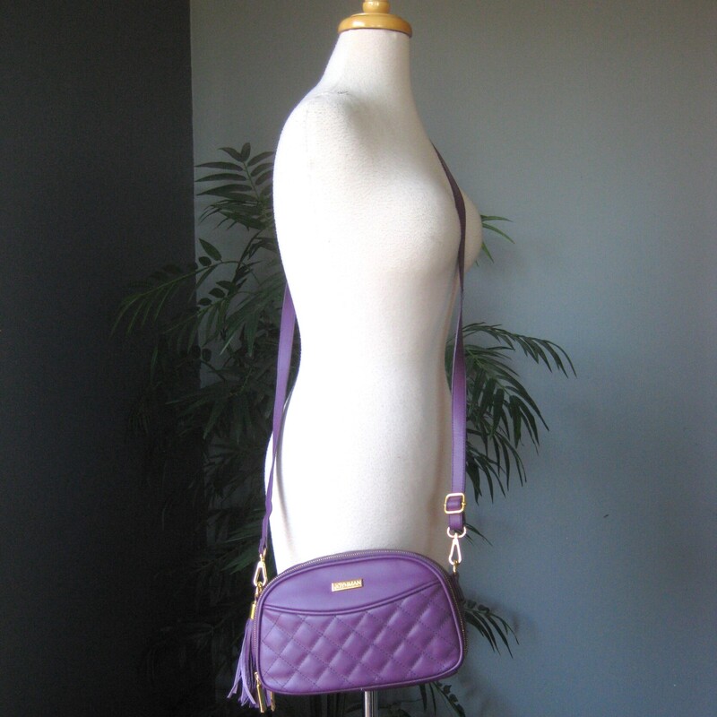 Double sided crossbody bag from Joy & Iman Joy Mangano<br />
Irresistable shade of Purple<br />
Quilted Crossbody Bag<br />
New without tags<br />
<br />
10-inches wide<br />
6-inches high<br />
3-inches deep<br />
Oval Shape<br />
Outer magnetic slip pocket<br />
2 zip compartments<br />
Card slots<br />
inner dividers<br />
Tassel bag charm (non-removable)<br />
Adjustable strap, 27  max, 14 minimum<br />
<br />
Like new condition!<br />
Thanks for looking!<br />
#81205