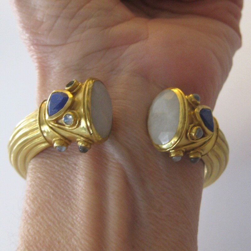 Julie Vos Hinged Cuff, Gold, Size: None<br />
stunning statement piece by Julie Vos<br />
It's a ancient world style chunky hinged cuff bracelet in gold (Plated) with faceted round milky quartz, triangular lapis and small round beads of a pale milky blue tinged stone.<br />
The bracelet is used.  The gold is mottled on the inside.  Marks of age on the outside but no dings or damage.<br />
I have small wrists and it fits me nicely, almost generously.<br />
<br />
thanks for looking!<br />
#81750