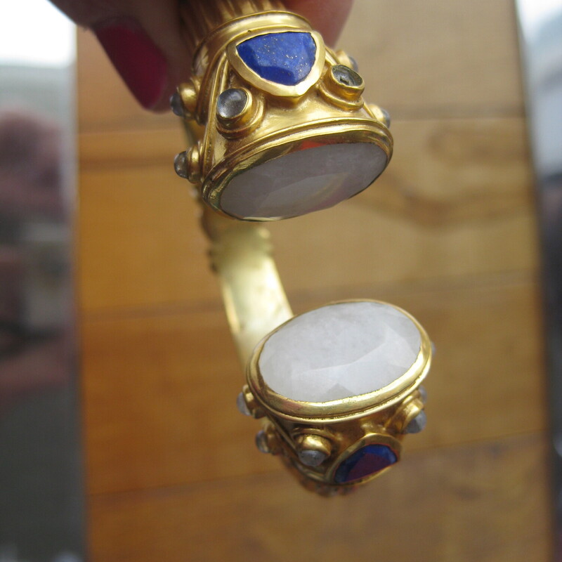 Julie Vos Hinged Cuff, Gold, Size: None<br />
stunning statement piece by Julie Vos<br />
It's a ancient world style chunky hinged cuff bracelet in gold (Plated) with faceted round milky quartz, triangular lapis and small round beads of a pale milky blue tinged stone.<br />
The bracelet is used.  The gold is mottled on the inside.  Marks of age on the outside but no dings or damage.<br />
I have small wrists and it fits me nicely, almost generously.<br />
<br />
thanks for looking!<br />
#81750