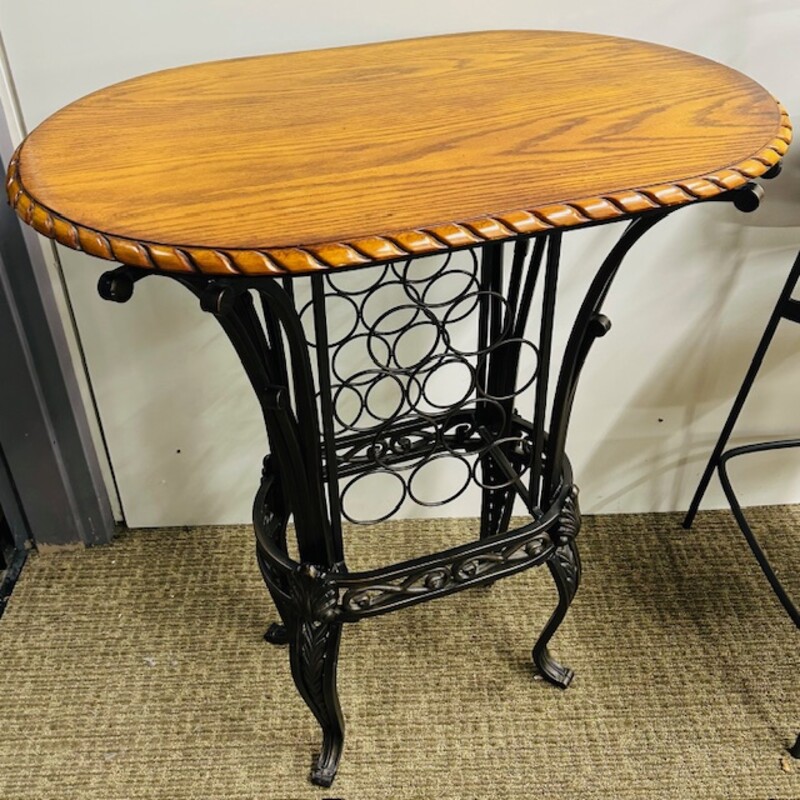 Braid Trim Oval Wood Pub Table<br />
Solid Brown Wood Top Braid Trim<br />
Base Iron with 11 Bottle Holder<br />
Size: 36x24x42H<br />
Requires Bar Height Chairs (Not Included)