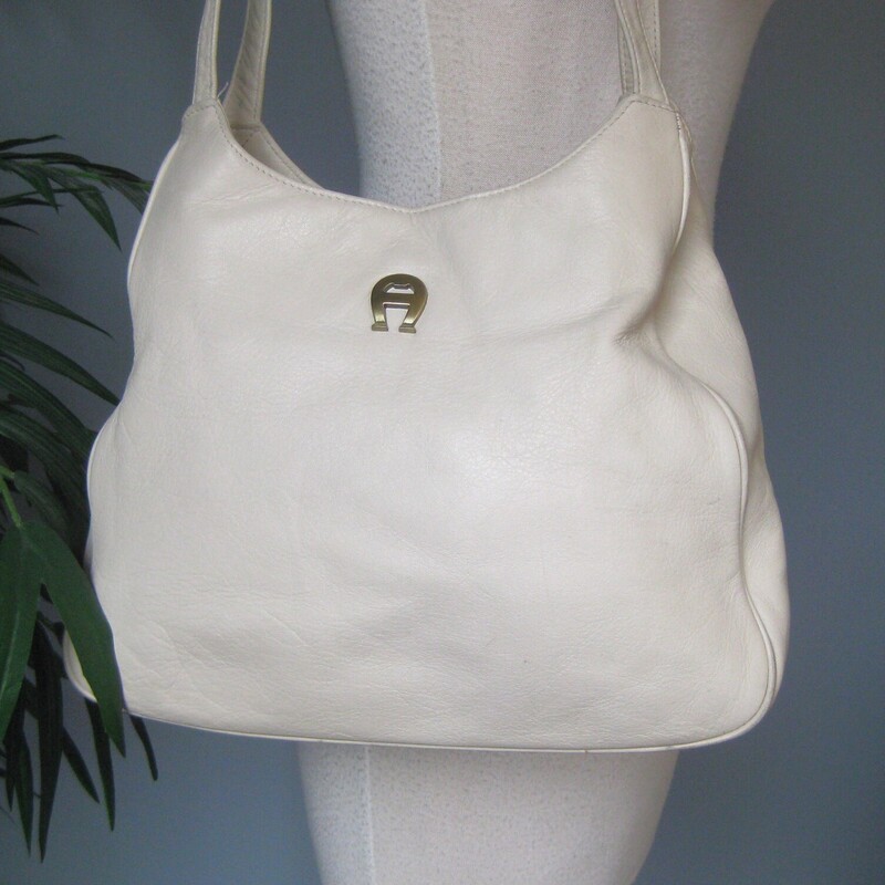 Vintage Etienne Aigner leather shoulder bag.<br />
White leather with two leather handles.<br />
two main compartmentes inside are divided by a large zippered compartments.  It also has a zippered pocket on one of the side walls.<br />
<br />
It is in good condition with some marks on the outside, including a pen mark that I was unable to get out completely.  Inside the light colored lining has some brown age spots and other wear.  No rips or big stains.<br />
Magnetic snap closure<br />
12 wide at the bottom, 9 wide at the top, 10.75 tall,  3 deep at the bottom<br />
Handle drop: 14.75<br />
<br />
Thanks for looking!<br />
#80381