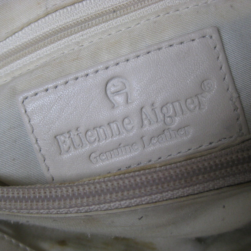 Vintage Etienne Aigner leather shoulder bag.<br />
White leather with two leather handles.<br />
two main compartmentes inside are divided by a large zippered compartments.  It also has a zippered pocket on one of the side walls.<br />
<br />
It is in good condition with some marks on the outside, including a pen mark that I was unable to get out completely.  Inside the light colored lining has some brown age spots and other wear.  No rips or big stains.<br />
Magnetic snap closure<br />
12 wide at the bottom, 9 wide at the top, 10.75 tall,  3 deep at the bottom<br />
Handle drop: 14.75<br />
<br />
Thanks for looking!<br />
#80381