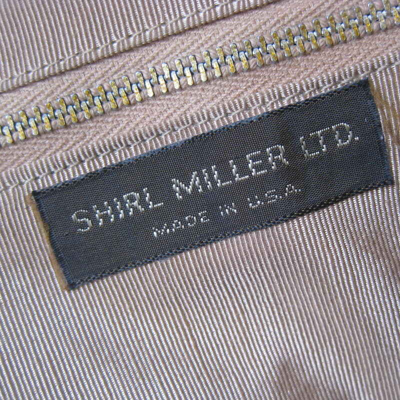 Chic gray leather bag by Shirl Miller a thin leather strap that you can wear on the shoulder, cross body or tucked to carry the bag like a clutch<br />
Sturdy shiny gold tone kiss lock frame<br />
Faille fabric lining with one zippered pocket<br />
Excellent condition, with some minor scratches on the gold frame<br />
Phone fits!<br />
W: 9<br />
H: 7<br />
Depth: aprox 1.5 the soft pouchy leather construction allows it toexpand when filled<br />
<br />
Thank you for looking!<br />
#80287