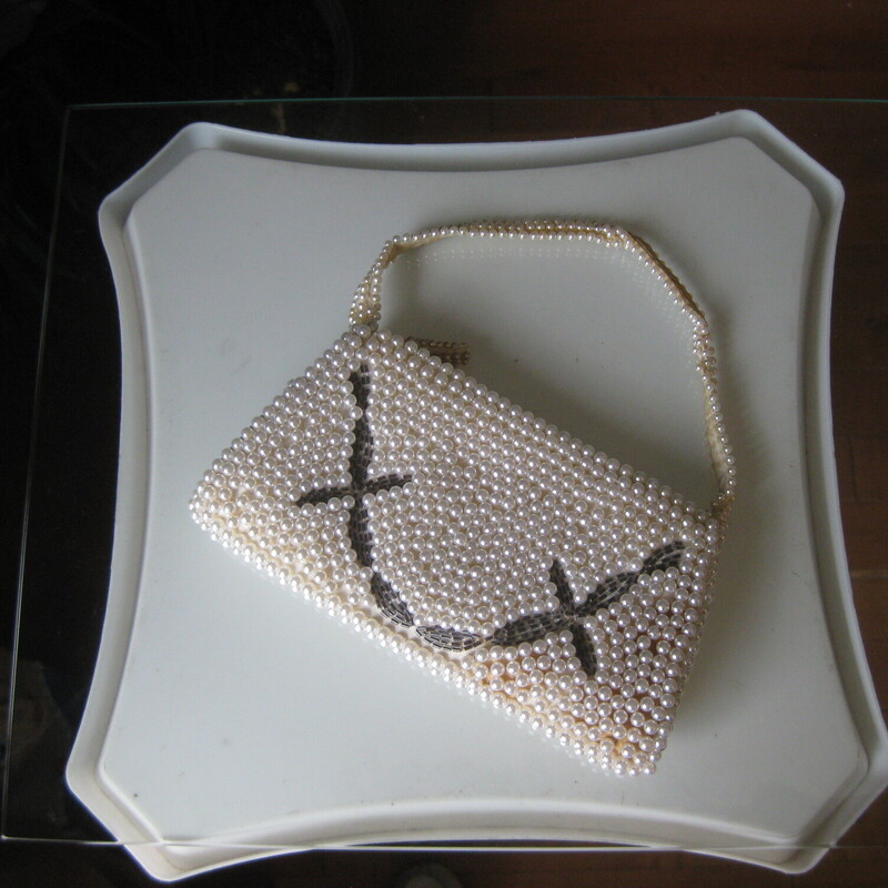 Teeny little vintage handbag, most likely made in Japan.  It's covered with white faux earls and it has an inset of smoky bugle beads in a curved design.<br />
The handle is also beaded and it has a top zipper.<br />
super narrow, it won't hold much.<br />
It came to me in a gift box, presumable from the store at which is was purchased way back when.  With age, (20's?) the matrix has darkened in the bottom right corner to a yellowy brown color.<br />
<br />
It's so small, you may be able to fit an old fashioned key and a lipstick in it, you can put some change in it for your bridge game, or use it as a keepsake bag or hide some money in as a pretty gift for a young lady.  Or maybe let the flower girl use it at the wedding.  She'll love it!<br />
<br />
Width: 7.5 at the bottom, 6 at the top<br />
Height: 4<br />
handle drop: 4<br />
<br />
thanks for looking!<br />
#81441