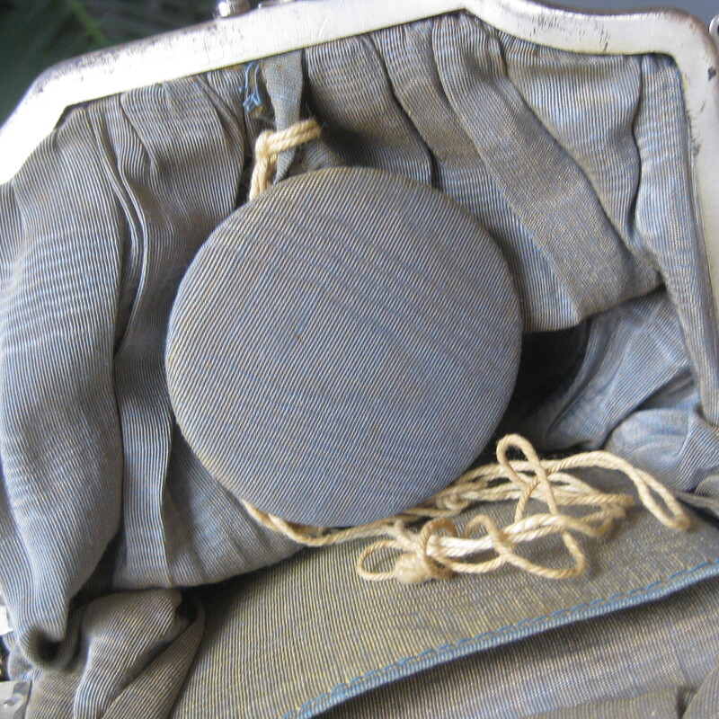 Pretty blue velvet pouch with a silver frame and a velvet handle.<br />
The bag is shaped like a pouch and has a tassel at the bottom.<br />
The frame is silver, possibly sterling ? molded in Art Nouveau style with a steel hinged clasp.<br />
Inside the lining is a watered silk like fabric,<br />
It's outfitted with a small round mirror and a tiny slip case with a snap closure.<br />
It also has a tiny silver key, added by its owner, attached with an old piece of string.<br />
what was it for?!<br />
It measures:<br />
6.25 wide at its widest part<br />
7.5 tall, flat when empty<br />
handle drop: 5.5<br />
<br />
excellent condition, tarnish and a bit of corrosion on the silver frame, clasp works smoothly, clean and damage free inside and out.<br />
thanks for looking!<br />
#67996