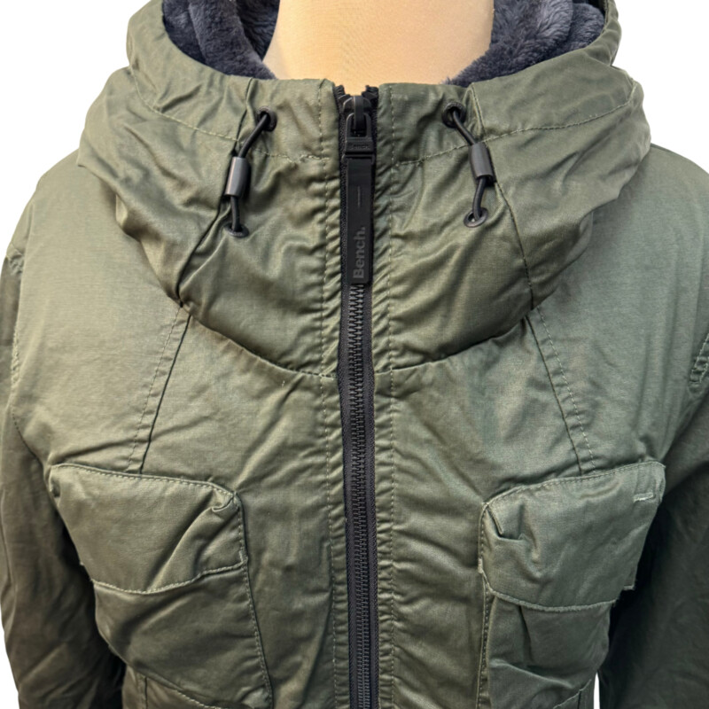 NEW Bench Kresiel B Jacket<br />
3 in 1 Water Resistant<br />
A jacket that comes with layers which can be worn together or separately.<br />
Army Green outer shell is breathable and water-resistant so you can stay dry on rainy days with the roomy hood and filled sealed seams.<br />
On cold days zip-in the silky-soft fleece liner to complete the coat.<br />
Ultimate technical outdoor versatility<br />
-Front zip closure<br />
-Adjustable hood<br />
-Liner has thumb holes to keep your hands warm<br />
-Outer shell is 100% Waxed Cotton<br />
Color: Army Green<br />
Size: Medium Fits Like a Snug Medium<br />
Retails for $259