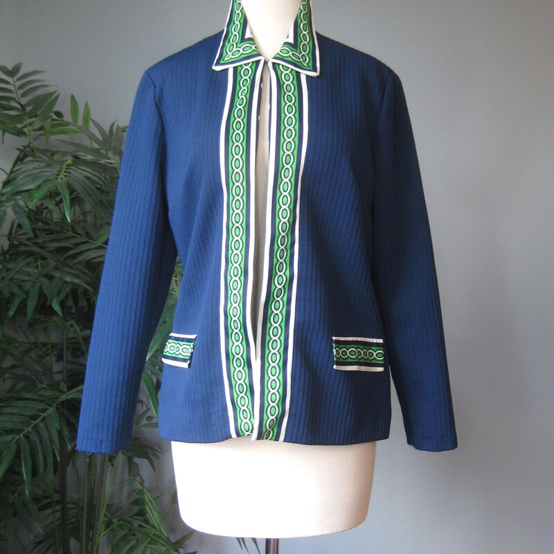 Here's a topper for someone who loves retro style. This big shirt or open cardigan is made of poly double knit, sturdy and pretty warm, washer and dryer safe. It's blue with green and white geometric contrast trim.
It has decorative pocket flaps on the front (no working pockets) and a single hook and eye closure at the neck.
Unlined
No tags
A little bit of stretch

Here are the flat measurements, please double where appropriate:

Shoulder to shoulder: 16
armpit to armpit: 20
Length: 24.75

Thanks for looking!
#73285