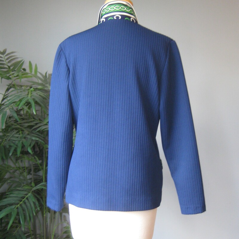 Here's a topper for someone who loves retro style. This big shirt or open cardigan is made of poly double knit, sturdy and pretty warm, washer and dryer safe. It's blue with green and white geometric contrast trim.<br />
It has decorative pocket flaps on the front (no working pockets) and a single hook and eye closure at the neck.<br />
Unlined<br />
No tags<br />
A little bit of stretch<br />
<br />
Here are the flat measurements, please double where appropriate:<br />
<br />
Shoulder to shoulder: 16<br />
armpit to armpit: 20<br />
Length: 24.75<br />
<br />
Thanks for looking!<br />
#73285