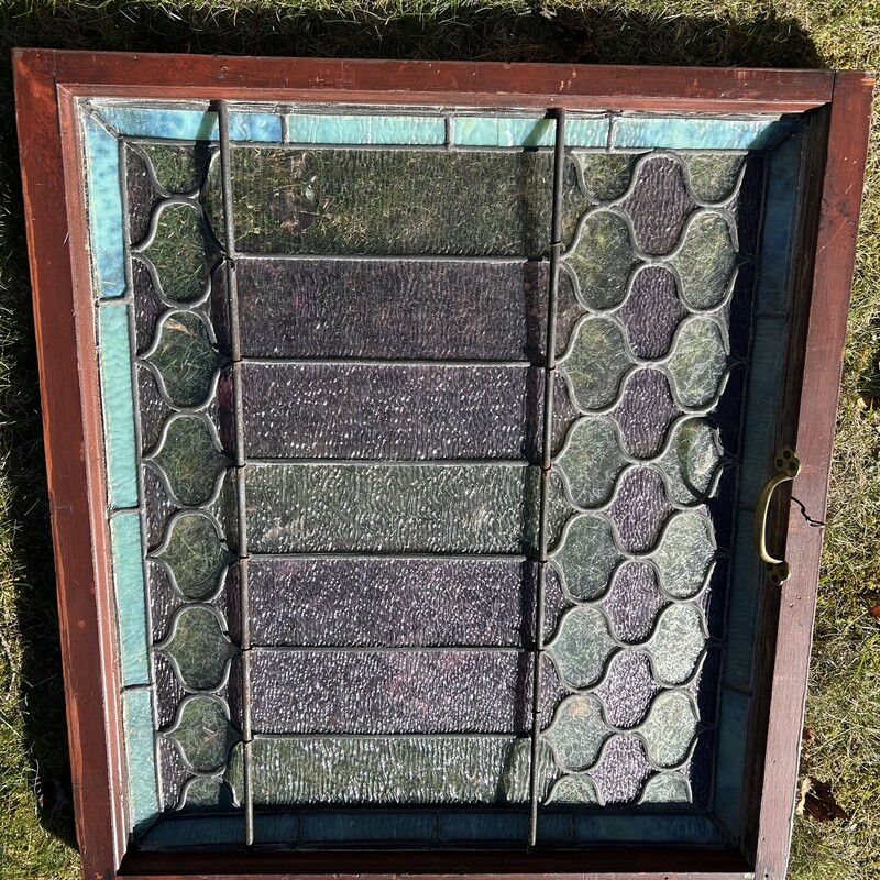 Stained Glass WIndow<br />
 Size: 32.5 X 30<br />
This is an original leaded stained glass window from a beautiful home.  All the glass is textured (translucent) allowing light to enter but it can not be seen through.  There is a beveled edge of a pale green with alternating panes of pale lavender and pale green.  The panes have differing texture patterns on them - some look like ice crystals that form on windows in the cold.  There is a wooden frame and two brass bars on the back side.  It is in very good condition.