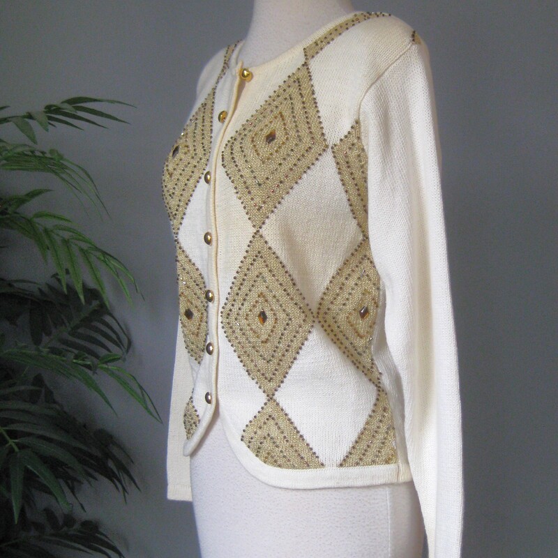 HI Sweater Girl, This adorable sweater from the 80s or early 90s in cream and gold features beads, 'jewels' and lurex. Great for the holidays<br />
It's from Dress Barn...... cringe? no. cute.<br />
round gold buttons and little shoulder pads.<br />
Plain on the back<br />
Excellent condition.<br />
cotton ramie blend<br />
Size S with some stretch<br />
Flat measurements, please double where appropriate:<br />
Shoulder to Shoulder: 15.5<br />
Armpit to Armpit: 19<br />
Width at bottom: 16<br />
length: 20.5<br />
Underarm sleeve seam length: 18.5<br />
<br />
Thanks for looking!<br />
#77676