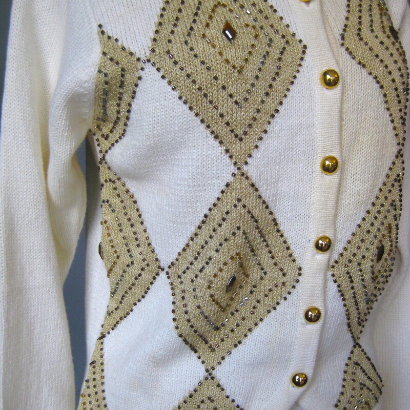 HI Sweater Girl, This adorable sweater from the 80s or early 90s in cream and gold features beads, 'jewels' and lurex. Great for the holidays<br />
It's from Dress Barn...... cringe? no. cute.<br />
round gold buttons and little shoulder pads.<br />
Plain on the back<br />
Excellent condition.<br />
cotton ramie blend<br />
Size S with some stretch<br />
Flat measurements, please double where appropriate:<br />
Shoulder to Shoulder: 15.5<br />
Armpit to Armpit: 19<br />
Width at bottom: 16<br />
length: 20.5<br />
Underarm sleeve seam length: 18.5<br />
<br />
Thanks for looking!<br />
#77676