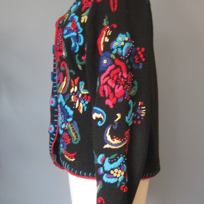 Chunky, colorful, warm  cardigan sweater by Gantos<br />
It's black with bold yarn embroidery dotted with metallic round beads<br />
The yarn covered buttons on the outside are decorative, inside the front edge are easy to work with small black plastic buttons.<br />
The front, sleeves and shoulders are decorated.<br />
Marked size small but should fit a modern medium as well<br />
flat measurements:<br />
armpit to armpit: 21<br />
width at hem: 21<br />
length: 21<br />
<br />
Excellent condition no flaws<br />
thanks for looking!<br />
#77507