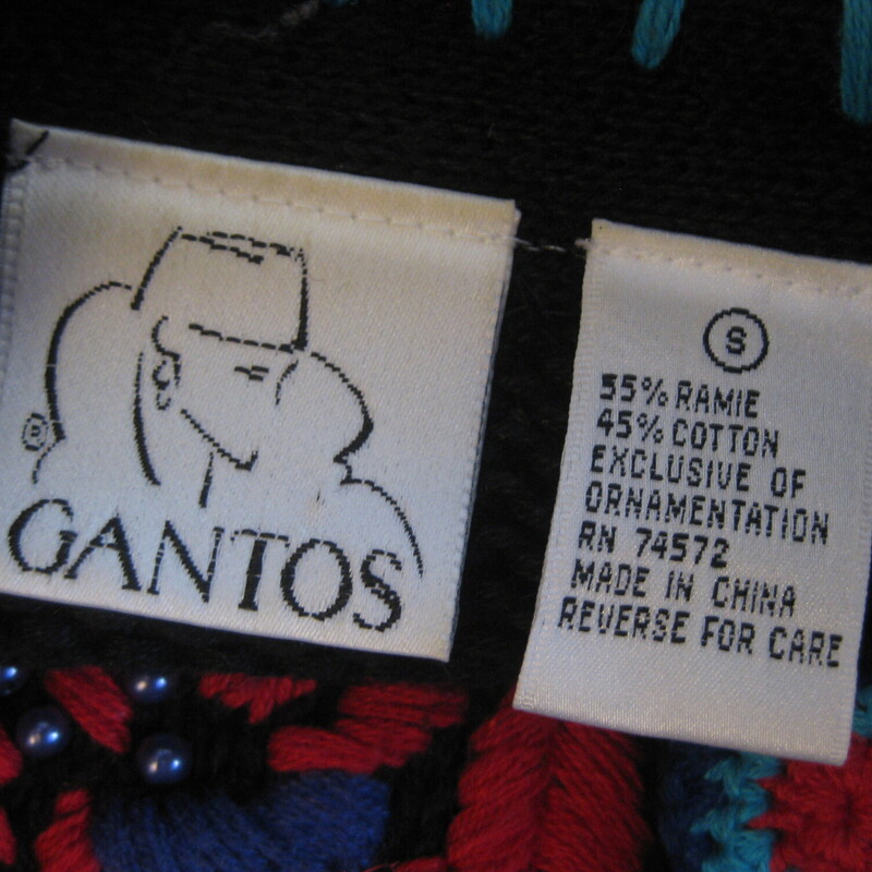 Chunky, colorful, warm  cardigan sweater by Gantos
It's black with bold yarn embroidery dotted with metallic round beads
The yarn covered buttons on the outside are decorative, inside the front edge are easy to work with small black plastic buttons.
The front, sleeves and shoulders are decorated.
Marked size small but should fit a modern medium as well
flat measurements:
armpit to armpit: 21
width at hem: 21
length: 21

Excellent condition no flaws
thanks for looking!
#77507