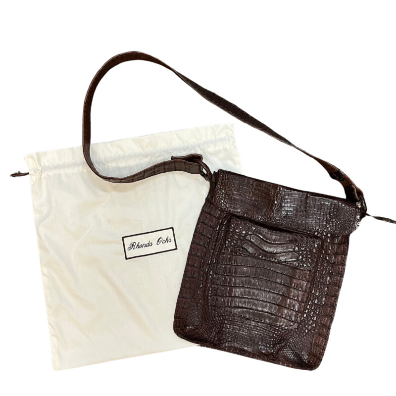 Rhonda Ochs Crocodile Crossbody Bag<br />
Snap Adjustable Shoulder Strap<br />
Dual Exterior Pockets<br />
Suede Lining & Single Interior Pocket<br />
Flap & Snap Closures at Top<br />
Dust Bag<br />
Color: Brown<br />
Estimated item measurements<br />
Shoulder Strap Drop: 20.75<br />
Height: 14.5<br />
Width: 12.5<br />
Depth: 0.75