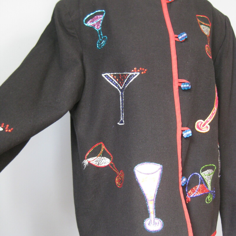 Nice jacket to wear on New Years Eve !<br />
High quality medium weight cotton with colorful barware and drinks embroidered all over it.<br />
Trimmed in red edging<br />
The embellishements continue on the back of the jacket and the sleeves<br />
Pretty blue plastic beads and loops down the front.<br />
Fully lined in polyester<br />
by Daniel K , Made in India<br />
Marked size LK<br />
<br />
Flat measurements:<br />
shoulder to shoulder: 17.5<br />
armpit to armpit: 22.75<br />
width at hem while buttoned: 23<br />
length: 25.75<br />
underarm sleeve seam: 17.25<br />
<br />
thanks for looking!<br />
#41870